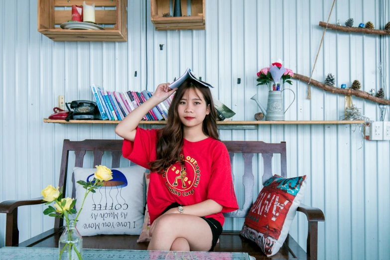 a woman in a red shirt sitting on a wooden bench, pexels contest winner, pop art, young adorable korean face, wearing a t-shirt, sitting on a store shelf, in style of lam manh