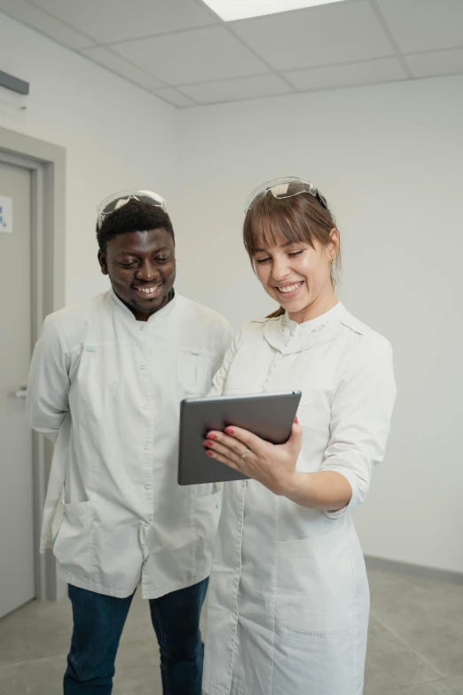 two people in lab coats looking at a tablet, pexels contest winner, grey, smiling slightly, photograph of 3d ios room, diverse