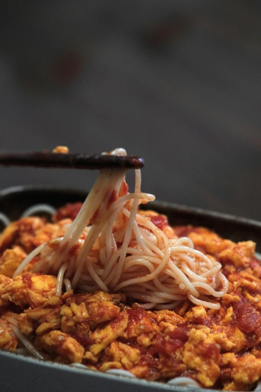 a close up of a bowl of food with chopsticks, arms made out of spaghetti, laces, 王琛, photographed for reuters