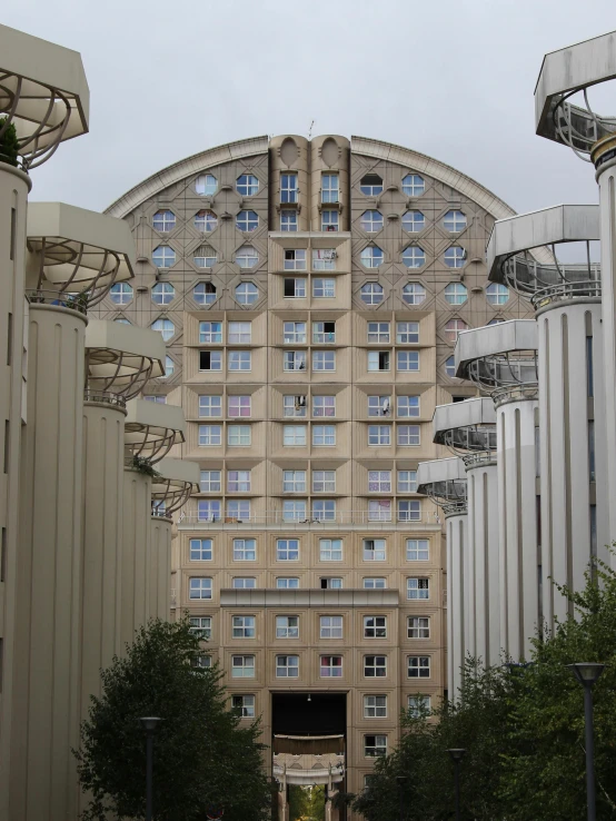 a very tall building with many windows near trees