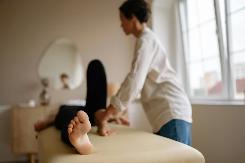 a woman getting a foot massage in a room, lachlan bailey, plain stretching into distance, nursing, slightly pixelated