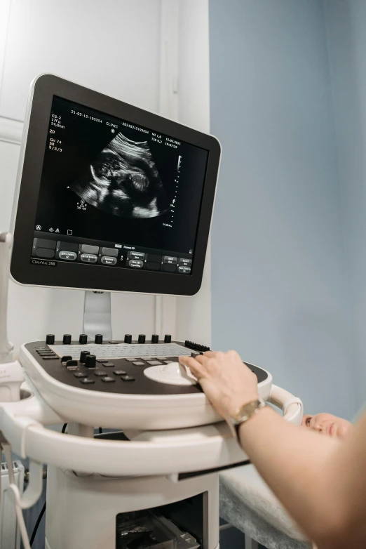 a woman sitting in front of a computer monitor, pexels, happening, membrane pregnancy sac, on an operating table, upper body close up, topographic scan