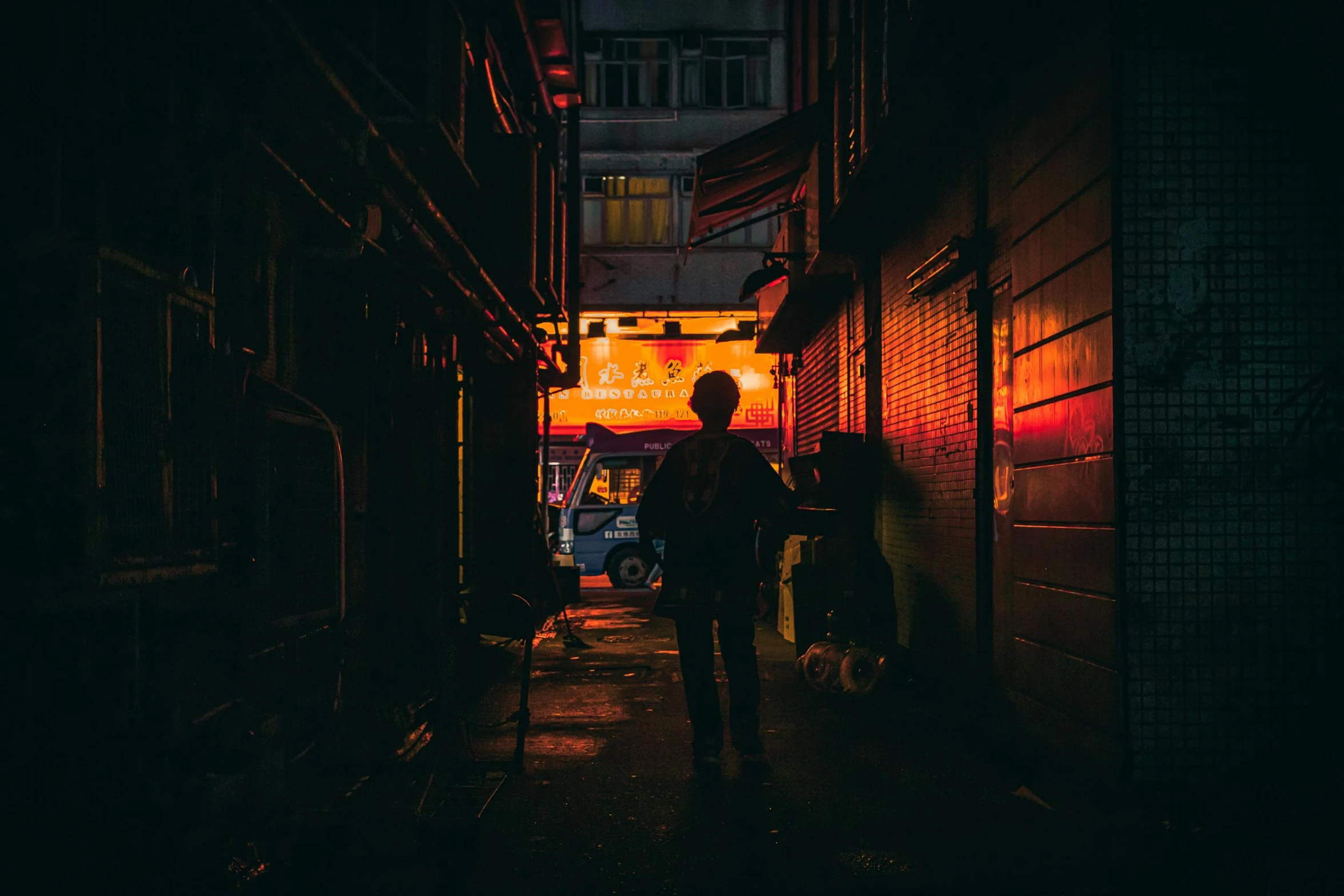 a person walking down a dark alley way, cyberpunk art, inspired by Liam Wong, pexels contest winner, kowloon walled city, taken at golden hour, taverns nighttime lifestyle, a photo of a man