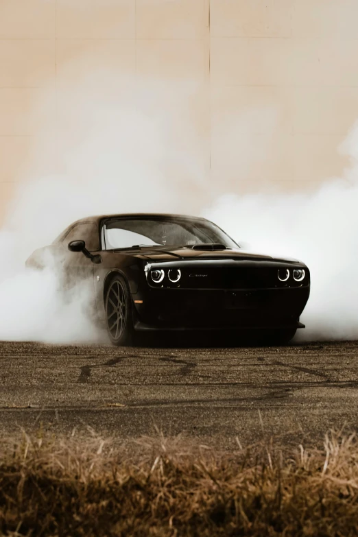 the dodge challenger muscle car kicking up smoke