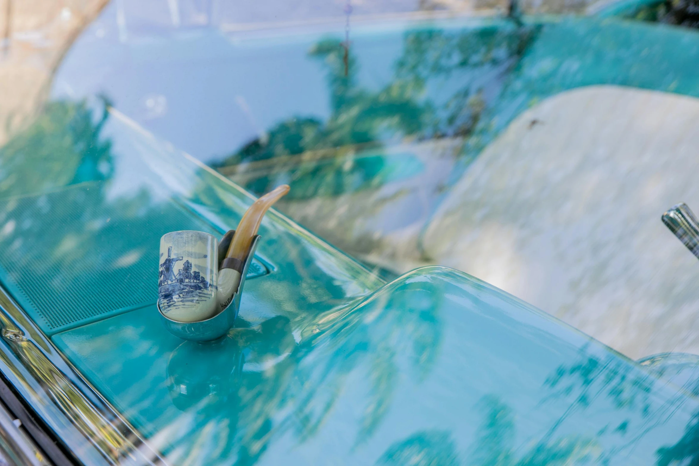 a blue car with a piece of art on it's hood