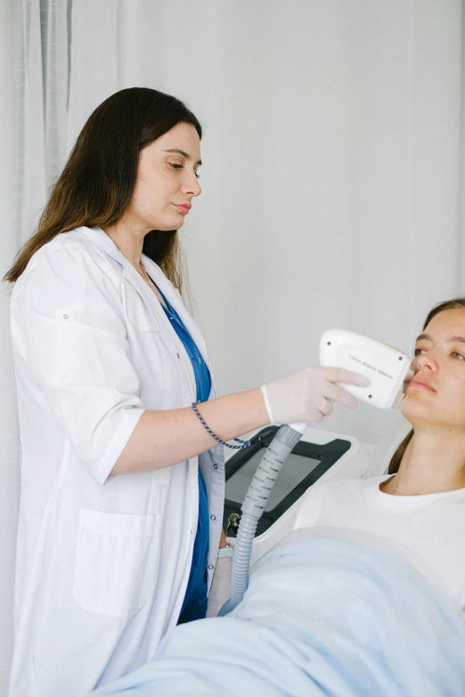 a woman in a hospital bed being examined by a doctor, by Adam Marczyński, square facial structure, white, technology, brown