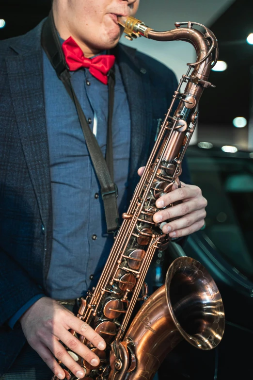 a saxophone player with a red bow tie playing the saxophone