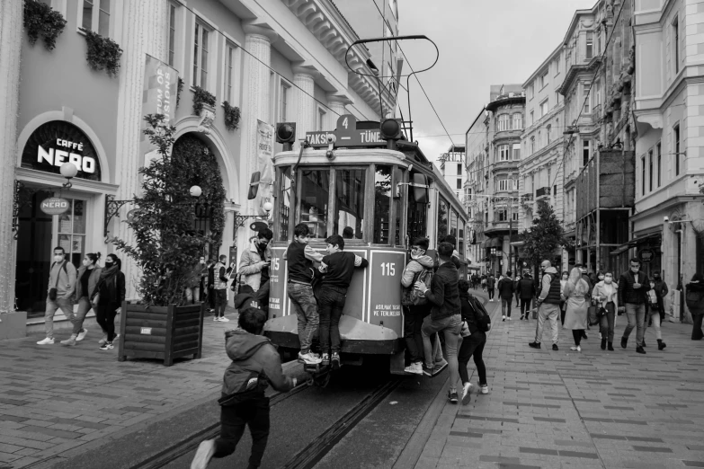 a black and white photo of a trolley on a city street, by Niyazi Selimoglu, everyone having fun, square, celebrity, mix