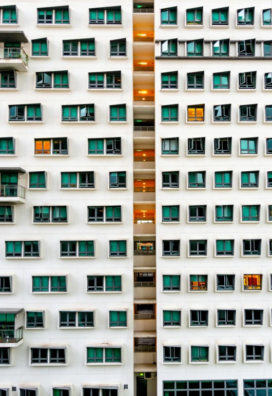 a couple of tall buildings next to each other, an album cover, inspired by Andreas Gursky, unsplash contest winner, house windows, singapore, green colours, portholes