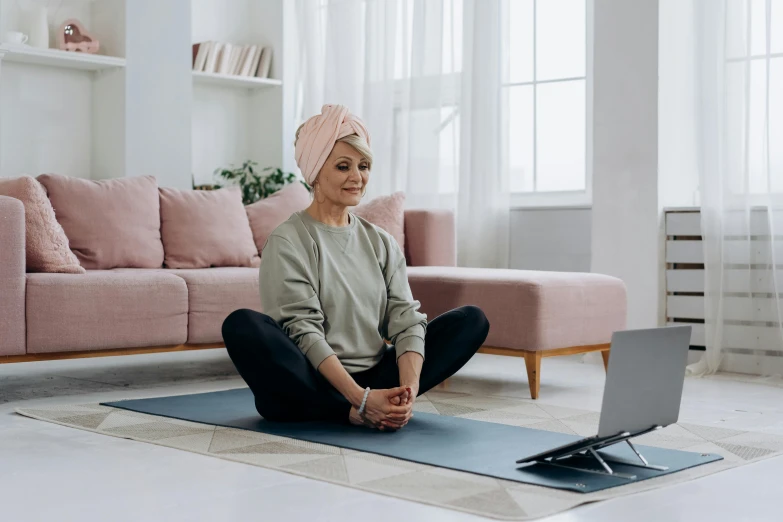 a woman sitting on a yoga mat in front of a laptop, by Liza Donnelly, hurufiyya, calmly conversing 8k, middle shot, julie heffernan, profile image