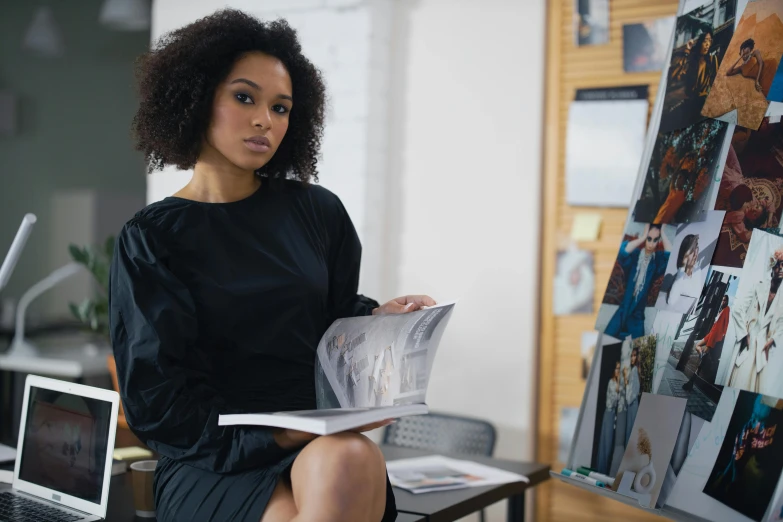 a woman sitting at a desk reading a newspaper, a portrait, by Joseph Severn, pexels contest winner, wearing a black dress, with afro, promotional image, wearing business casual dress