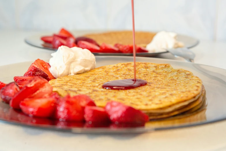 someone is spreading syrup onto a stack of pancakes