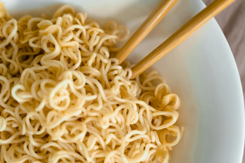 a bowl of noodles with chopsticks in it, unsplash, dynamic closeup, 2019 trending photo, ultrarealistic, light tan