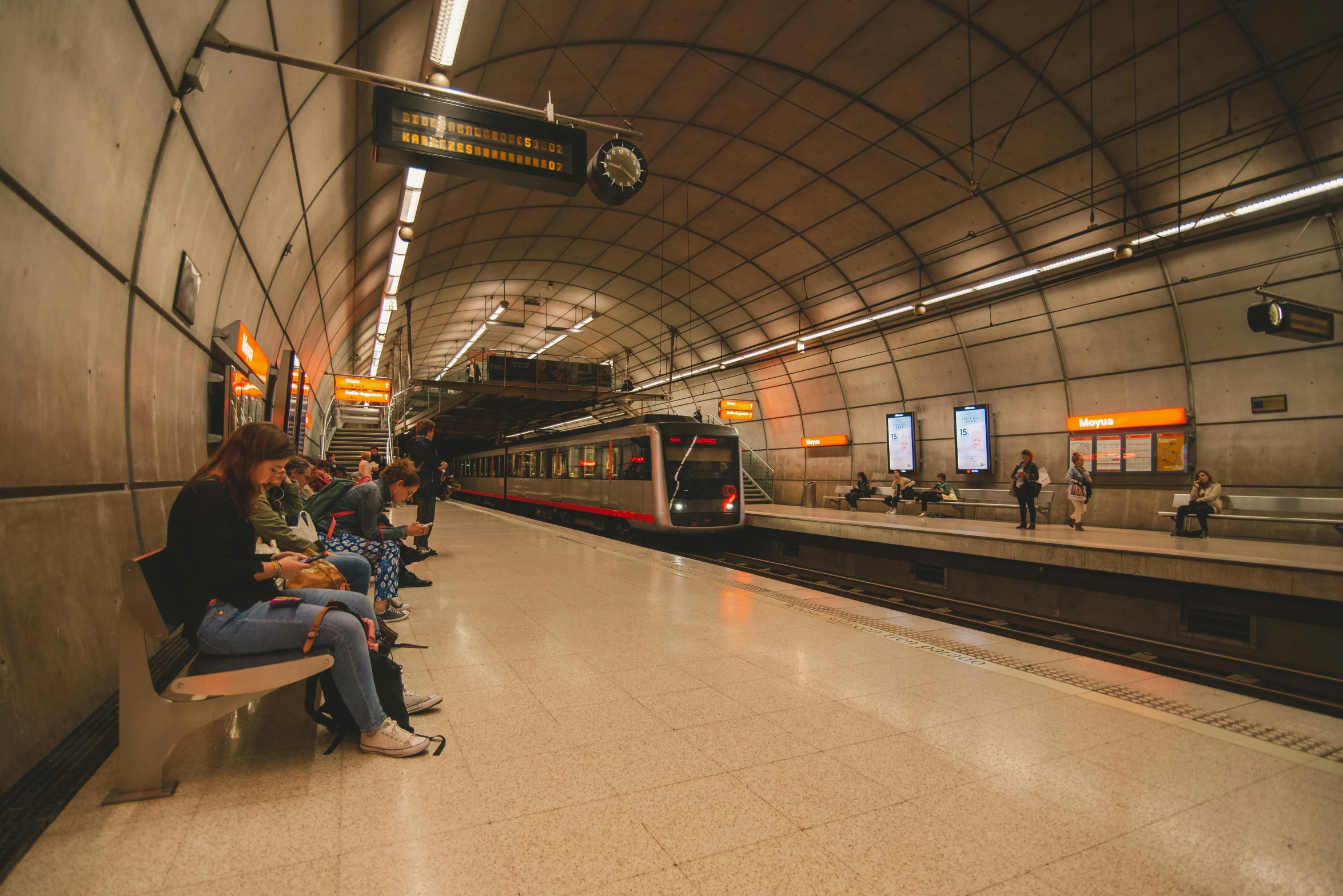 people sitting on benches while at a train station