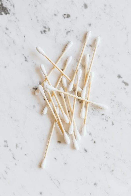 a pile of toothpicks sitting on top of a table, white marble and gold, nasal strip, lots of white cotton, birch