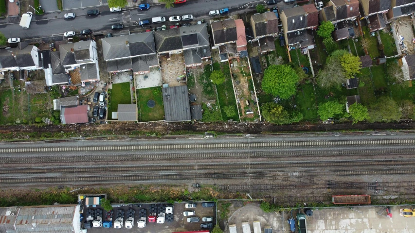 a bird's eye view of a city street, inspired by Thomas Struth, unsplash, photorealism, rail tracks lead from the mine, suburban garden, 2000s photo, 3 meters