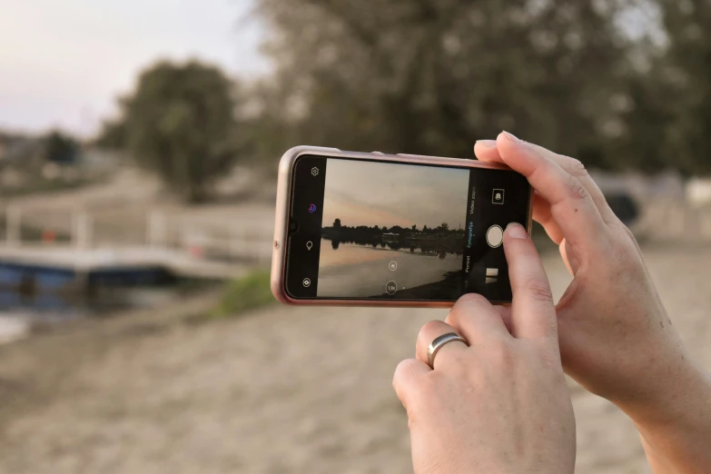 a person taking a picture with a cell phone, a picture, pexels contest winner, realism, on a lake, home video footage, turned back to camera, flash photo