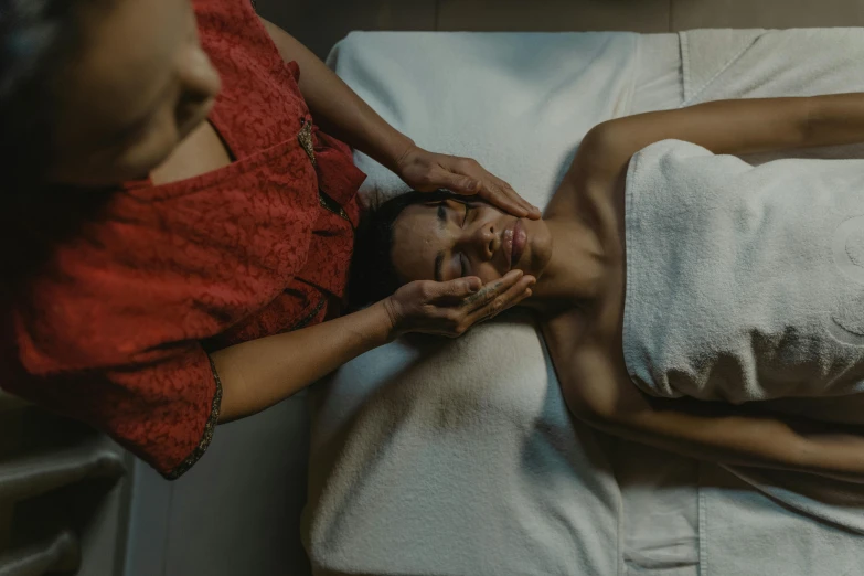 a woman getting a facial massage at a spa, by Matija Jama, pexels contest winner, assamese aesthetic, mid body, still frame, cinematic full shot