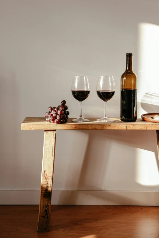 three glasses of wine on a wooden bench