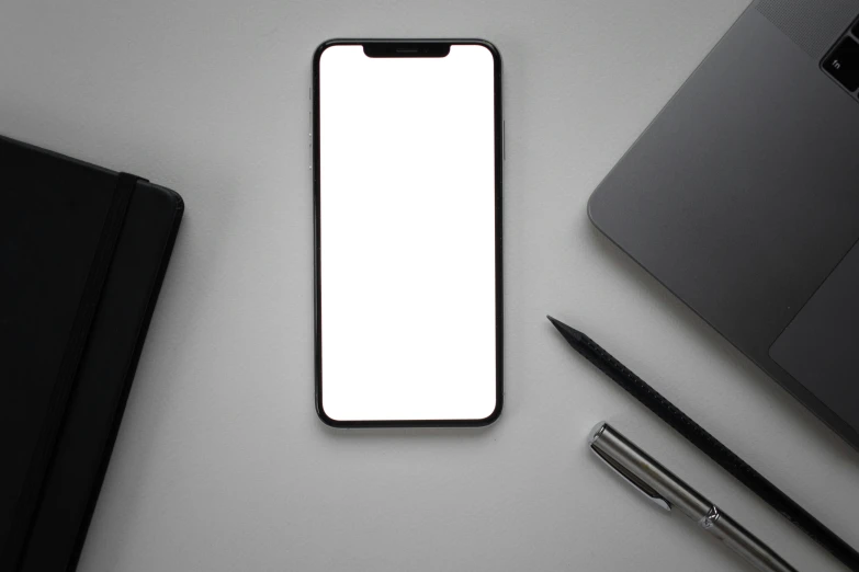 a cell phone sitting on top of a desk next to a laptop, trending on pexels, minimalism, clean black outlines, square face, hq 4k phone wallpaper, solid gray