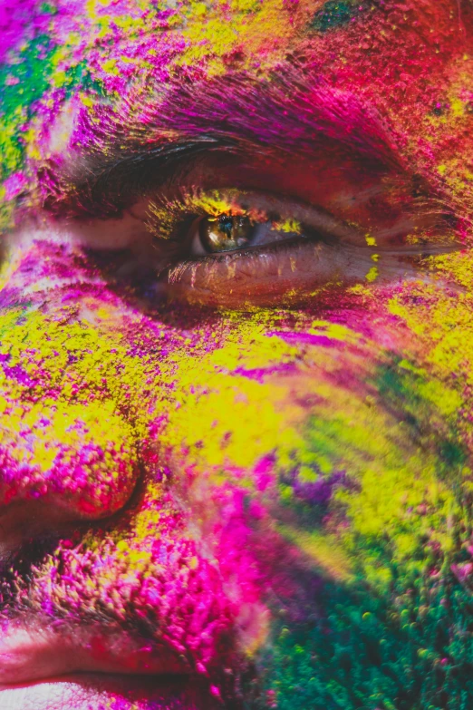 a man with colorful paint on his face, inspired by Steve McCurry, trending on pexels, color field, intricate artwork. neon eyes, magical sparkling colored dust, ( ( ( colorful ) ) ), colour print