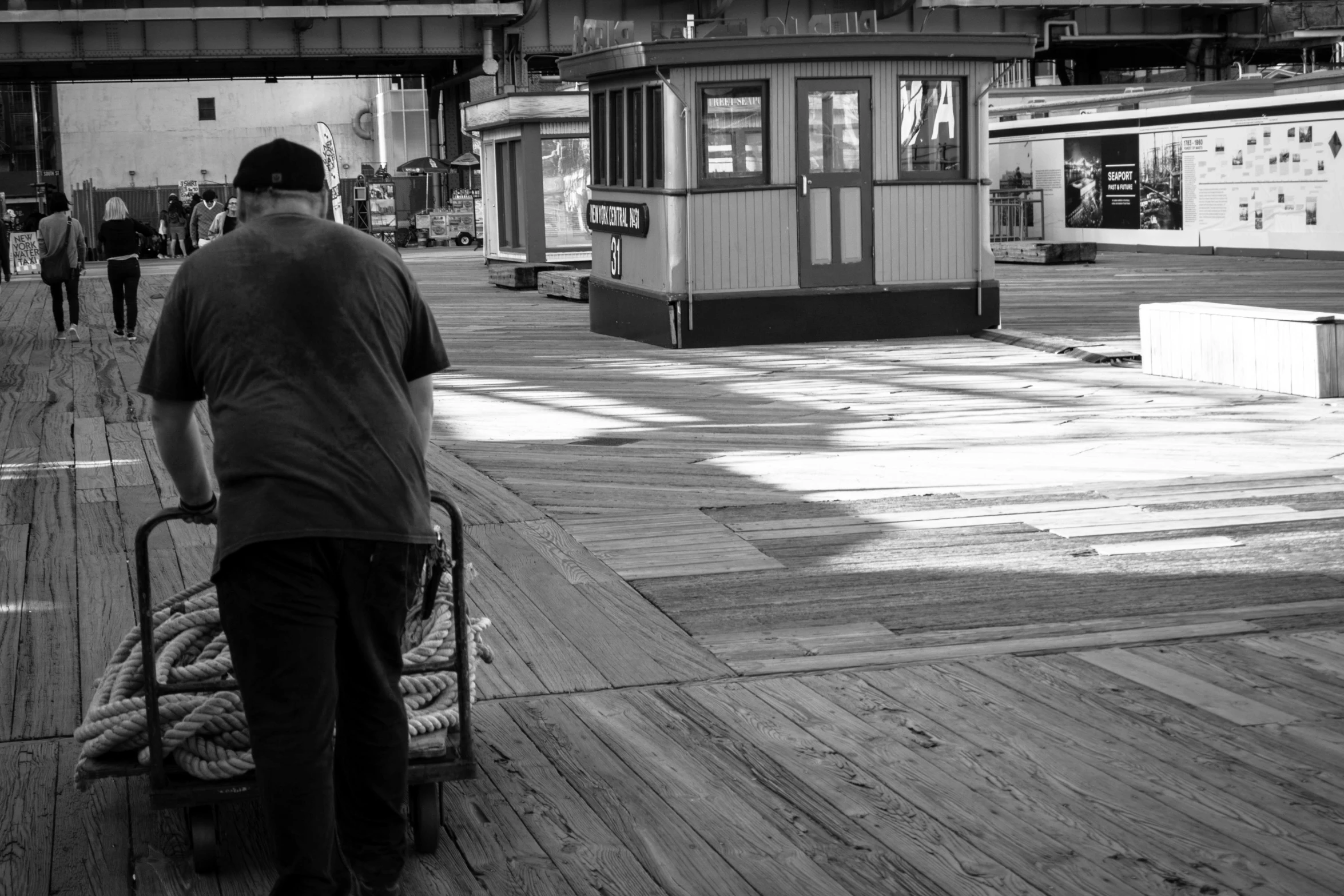 a person standing on a boardwalk with a cart