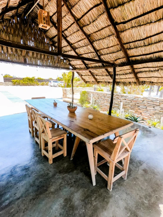 the dining table under the thatched roof is a perfect place for a break