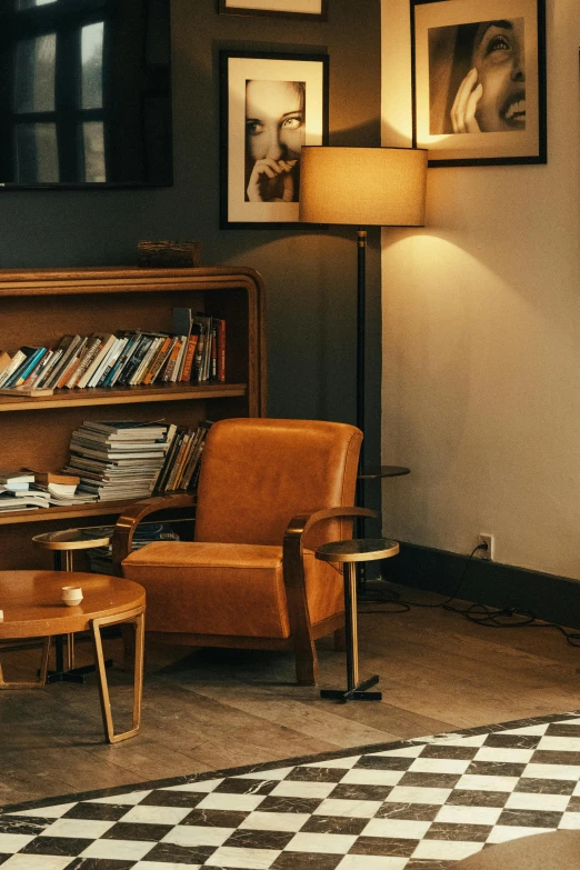 a brown chair sitting in front of a wooden shelf filled with books