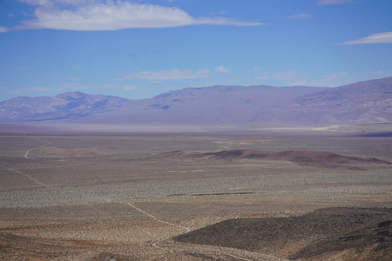 two large mountains stand in the distance of this desert landscape