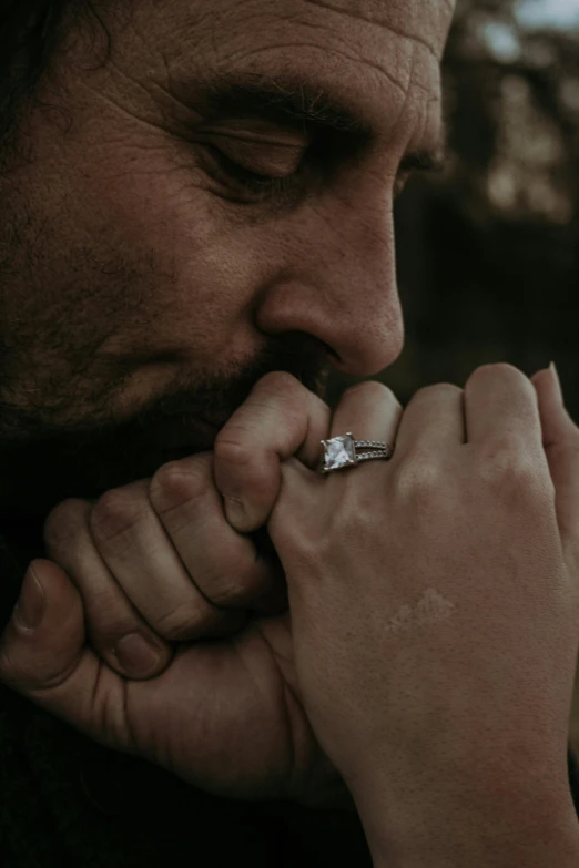 a man with a ring on his finger, pexels contest winner, jesus hugging a woman, hand on her chin, square, engagement ring ads