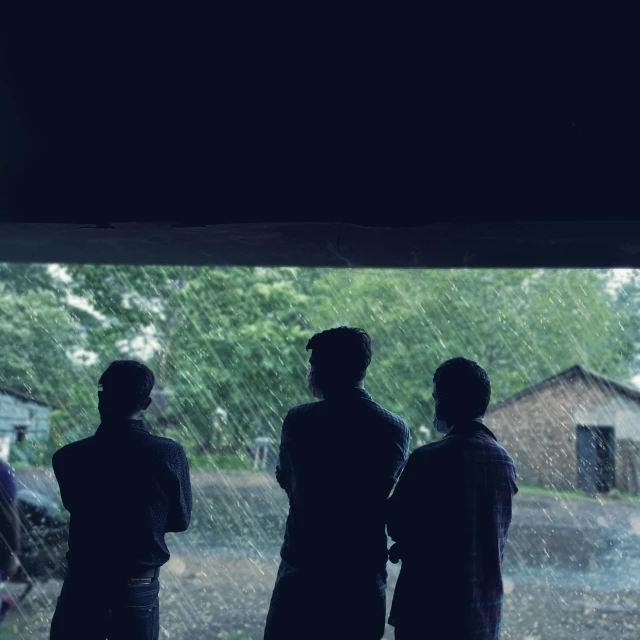 a group of people standing in the rain, an album cover, unsplash, conceptual art, looking out window, movie still 8 k, in front of a garage, summertime