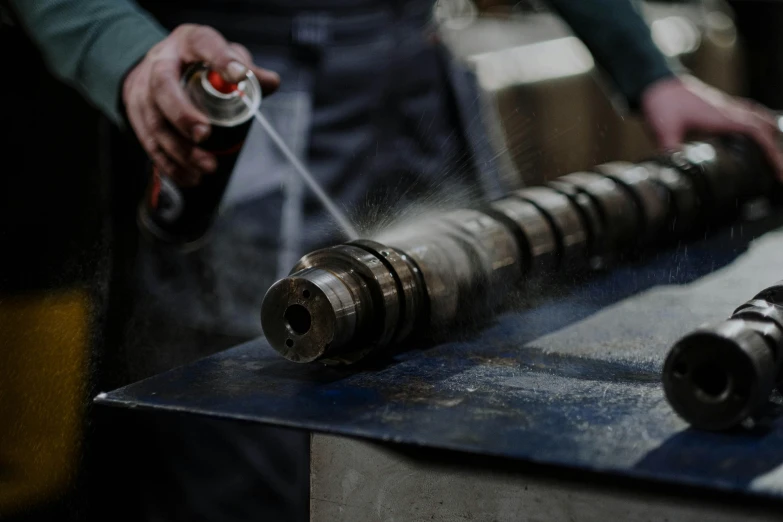 a close up of a person spraying something with a spray can, pexels contest winner, woodlathe, leaking pistons, a handsome, spiralling