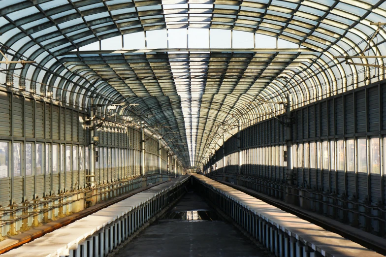 a train that is sitting inside of a train station, inspired by Thomas Struth, unsplash contest winner, art nouveau, sky bridges, calatrava, demur, steel archways