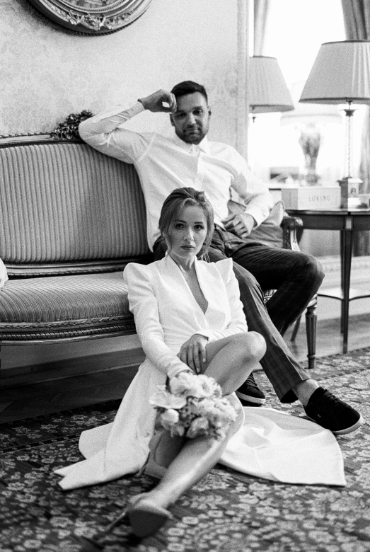 a man and a woman sitting on a couch, a black and white photo, unsplash, renaissance, bride and groom, in style of terry richardson, white clothes, olga buzova