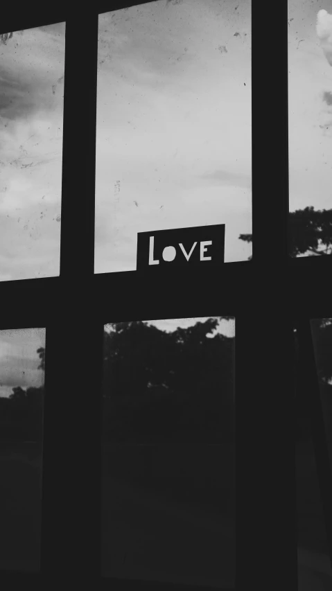 a black and white photo of a window with love written on it, unsplash, low quality photo, thumbnail