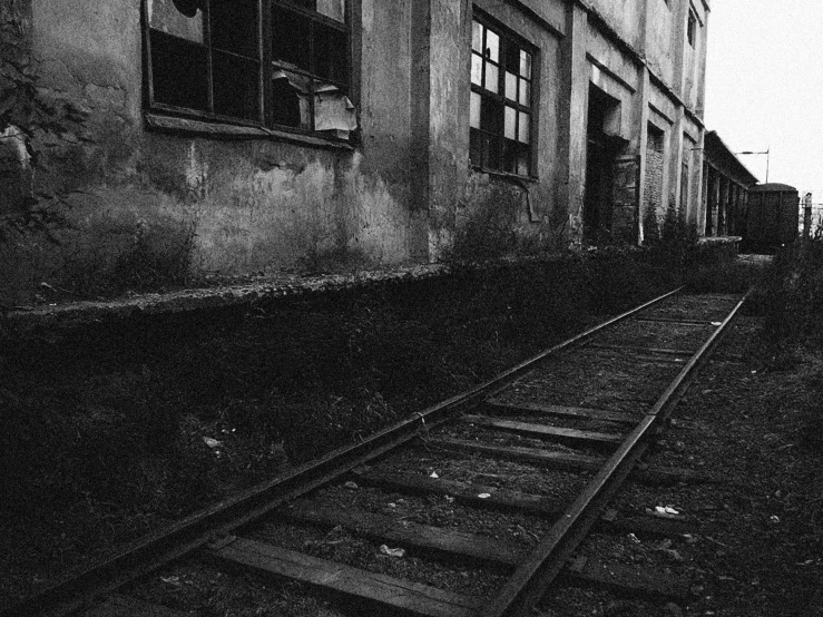 a black and white photo of a train track, a black and white photo, by Lucia Peka, location of a dark old house, taras susak, stood in a factory, yard