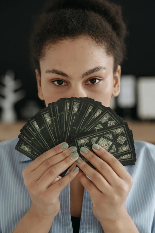 a woman holding a fan of money in front of her face, pexels contest winner, renaissance, holds playing cards, black and green scheme, in an office, thumbnail