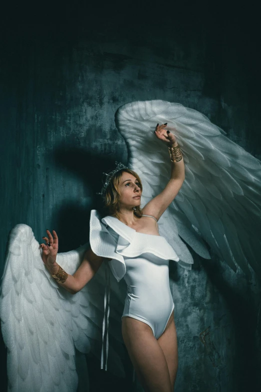 a woman in a white bodysuit with angel wings, an album cover, inspired by David LaChapelle, pexels contest winner, renaissance, sydney sweeney, winged boy, low key, stormy