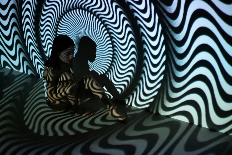 a woman sitting on top of a black and white floor, a hologram, interactive art, oganic rippling spirals, stood in a tunnel, lesbians, shadow play