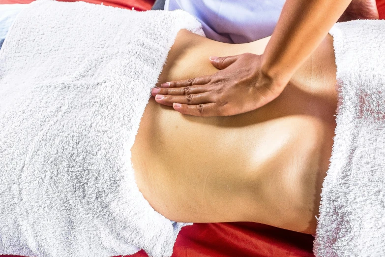 a woman getting a back massage at a spa, a photo, massurrealism, belly button showing, caulfield, thumbnail, manly