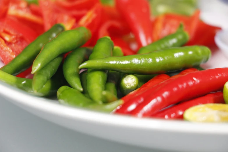 a white bowl filled with green and red peppers, pexels, spicy, zoomed in, sunny, longque chen