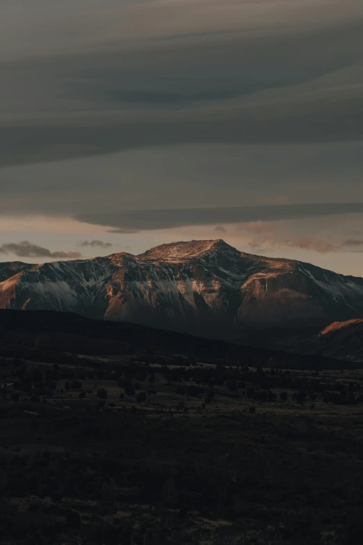 an image of mountains at dusk with clouds