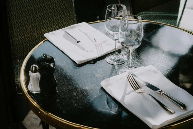 a table has silverware, wine glasses, and napkins on it