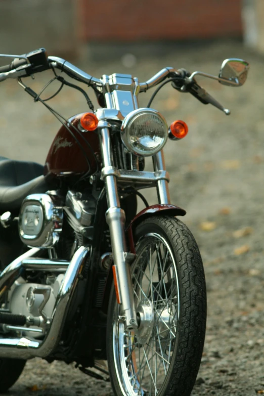 a close up of a motorcycle parked on a dirt road, square, taken in the late 2000s, custom headlights, brown