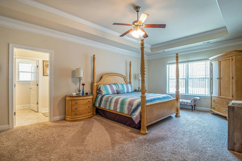 the bedroom has a ceiling fan, dressers and a bed in it