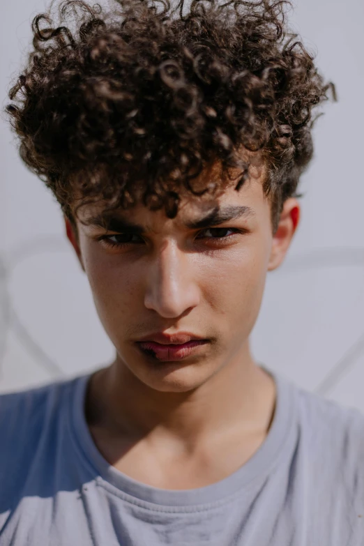 a close up of a person with a skateboard, trending on pexels, renaissance, boy with neutral face, curly pixie hair, 14 yo berber boy, nonbinary model