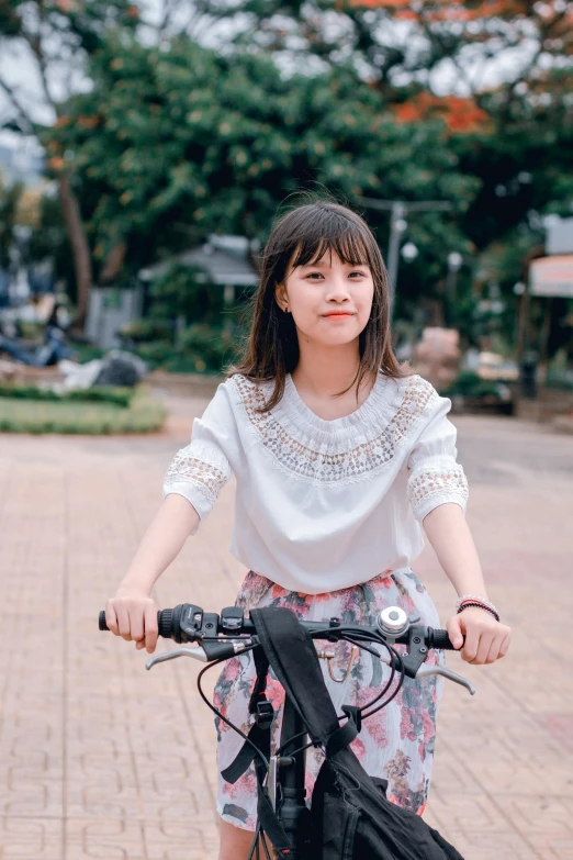 a woman riding a bike down a brick road, by Tan Ting-pho, pexels contest winner, realism, cute kawaii girl, 🤤 girl portrait, shirt, student