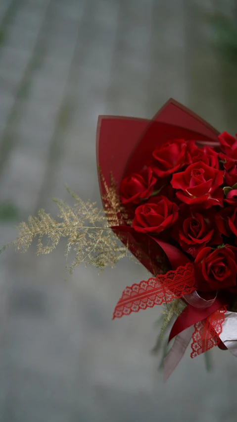 red roses in a small bouquet with a small lace ribbon