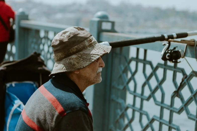 a man standing on a bridge with a fishing rod, pexels contest winner, photorealism, sniper! middle age man, people watching, hat covering eyes, portrait of a old