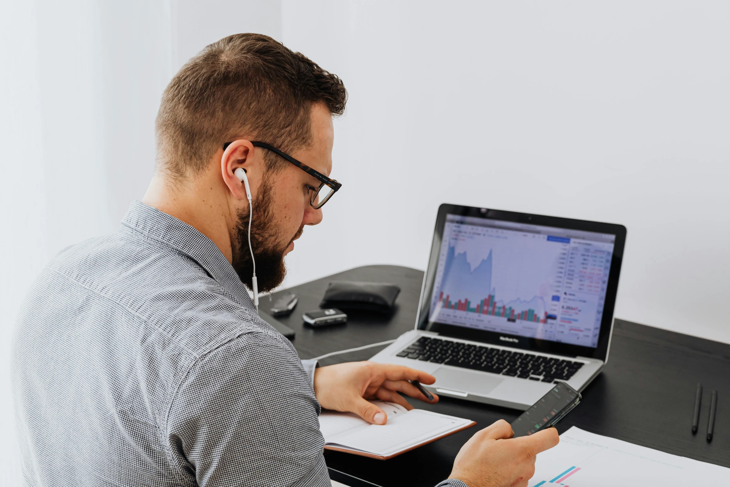 a man sitting at a desk using a laptop computer, trending on pexels, with head phones, lachlan bailey, professional profile picture, charts